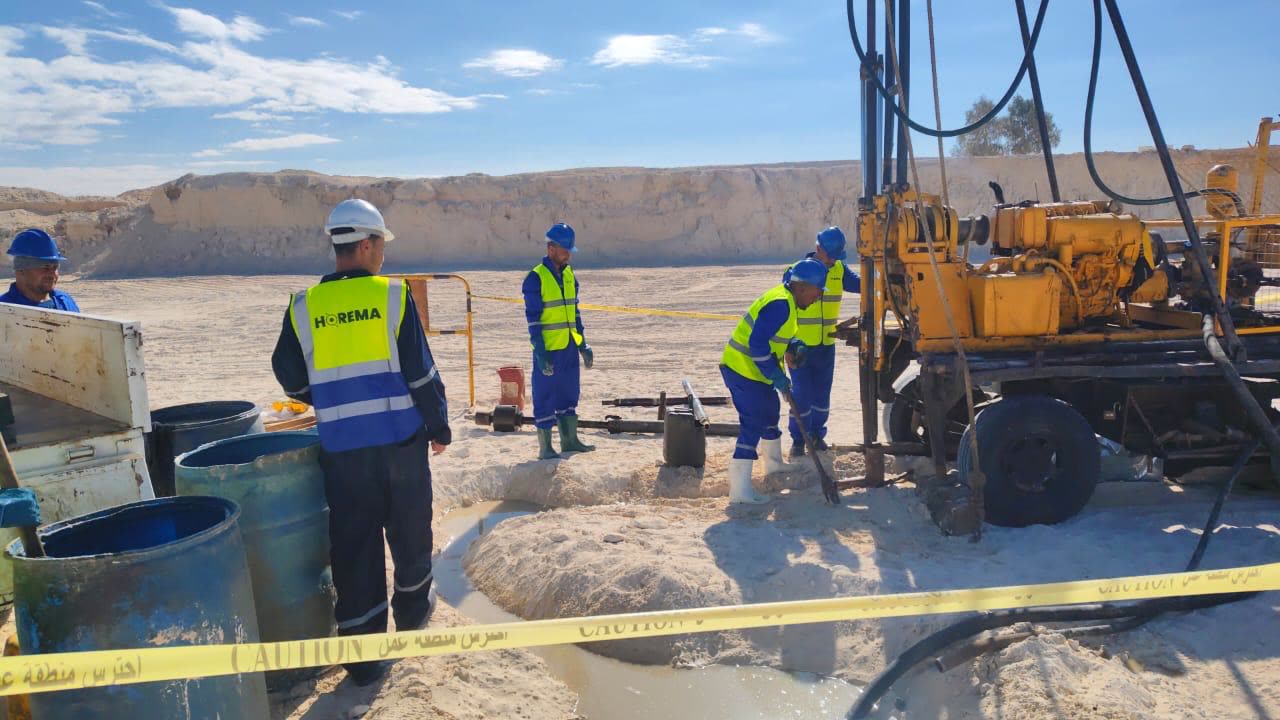 Horema field team behind cordoned safety tape while a borehole is flushed