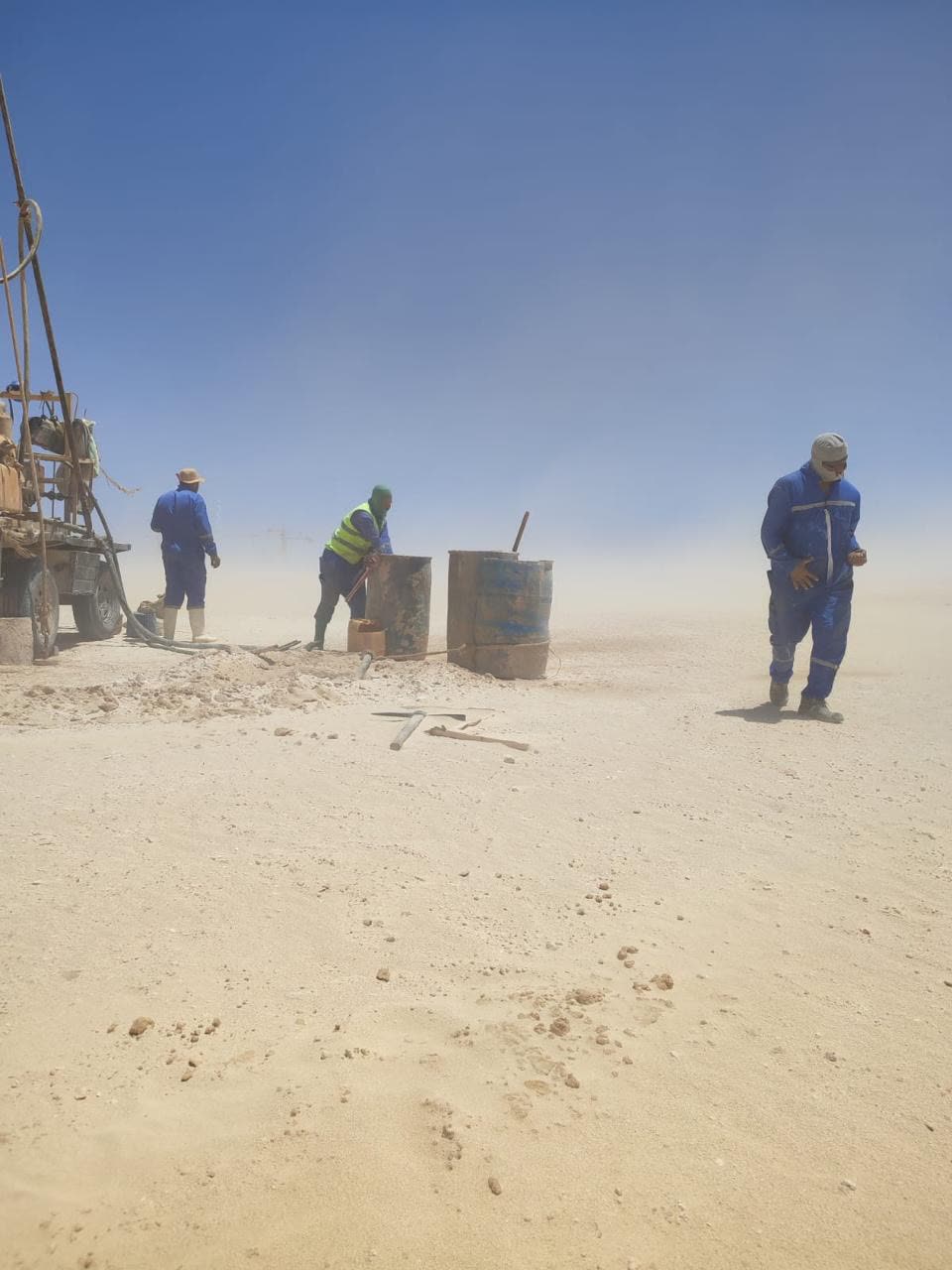 Horema crew drilling in an open desert plain during blowing dust